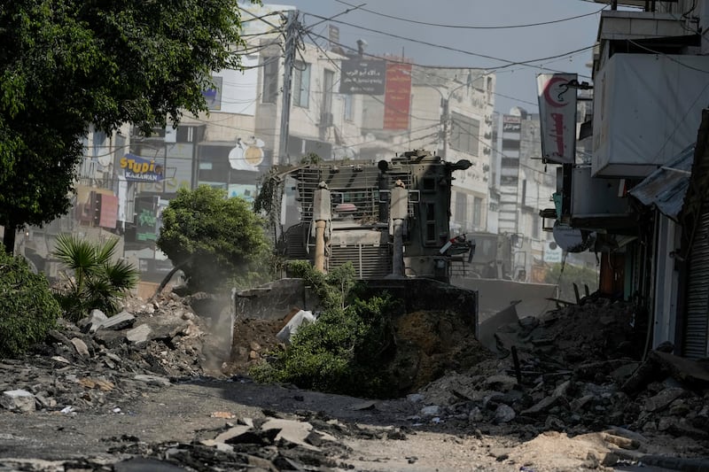 An Israeli military bulldozer tears up a road littered with rubble during an army raid in Jenin, West Bank (Majdi Mohammed/AP)