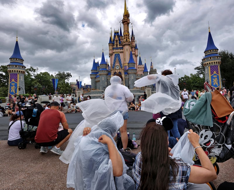 Guests at the Magic Kingdom break out ponchos at Cinderella Castle (Joe Burbank/Orlando Sentinel via AP)