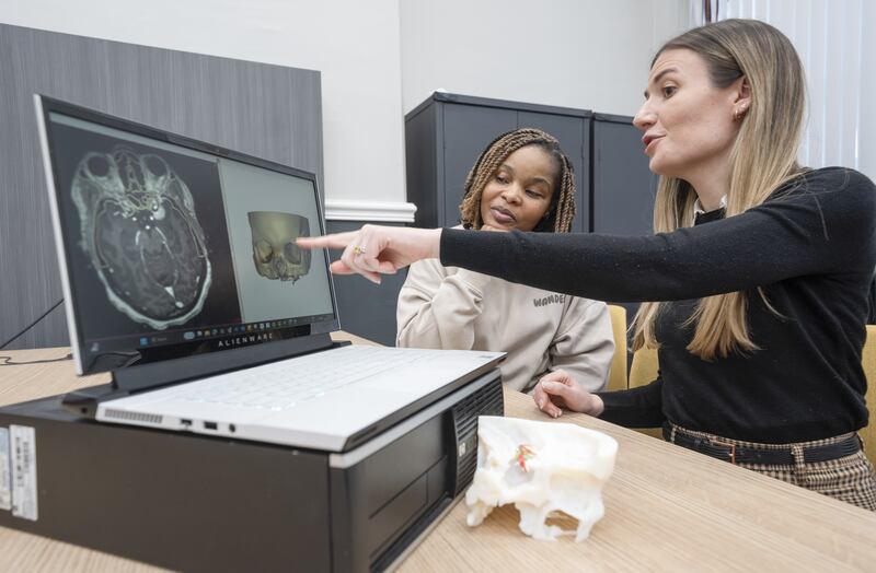 (l to r) Ruvimbo Kaviya and biomedical engineer Lisa Ferrie look at an MRI scan and 3D digital model of the tumour