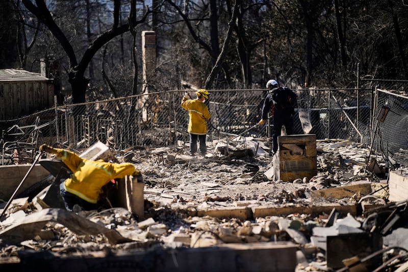 A search and rescue crew sifts through the wreckage of a home destroyed by the Eaton Fire (John Locher/AP)