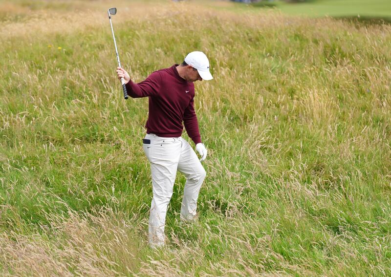 Rory McIlroy looks down at the rough after only moving his ball a few yards on the fourth hole