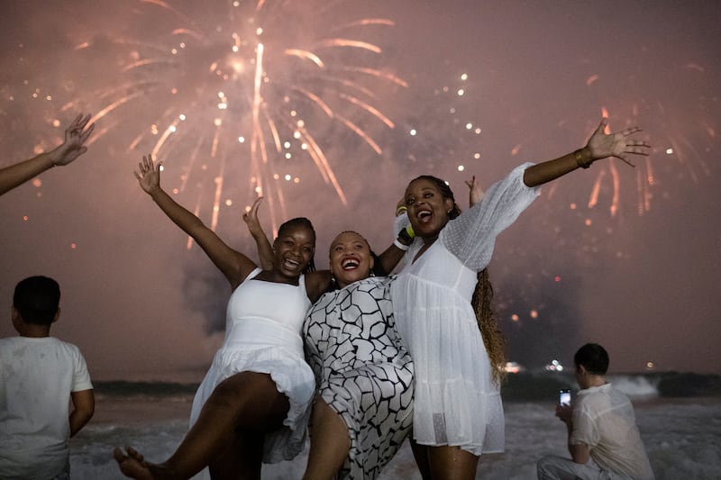 People celebrate as fireworks light up the sky over Copacabana Beach during New Year’s celebrations in Rio de Janeiro(AP/Bruna Prado)