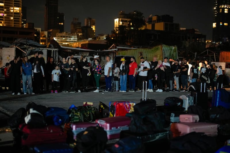 Turkish citizens stand in line waiting for their turn to board two Turkish military ships to evacuate them from Lebanon to Turkey in Beirut port (Emrah Gurel/AP)