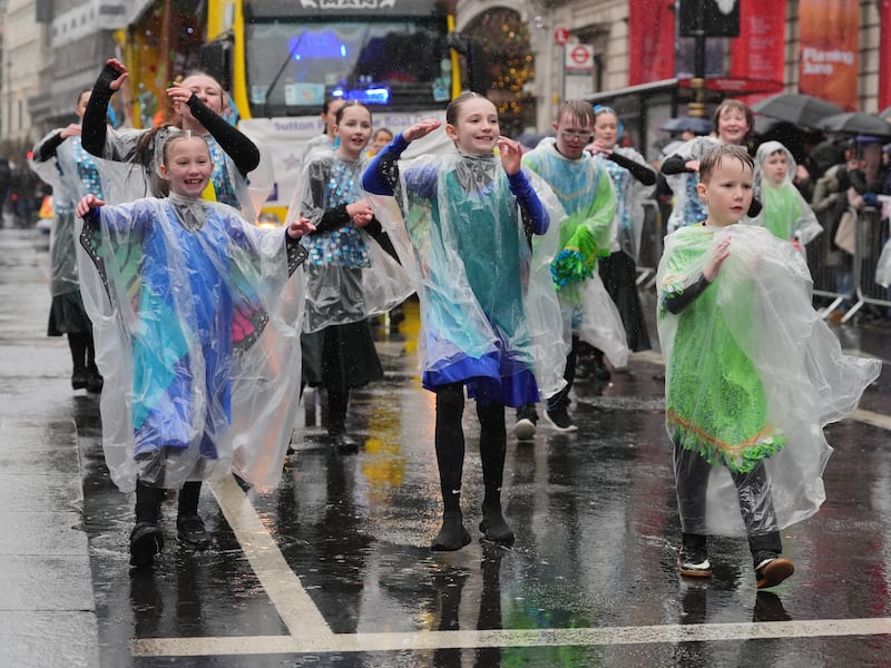 Performers didn’t let the rain dampen spirits as they danced in the New Year’s Day parade