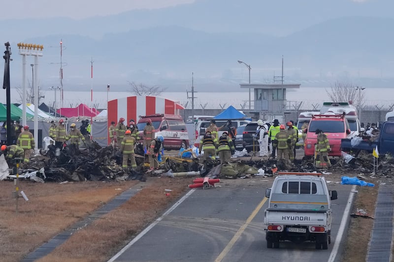 Rescue team members work at the site of the plane crash in South Korea (Ahn Young-joon/AP)