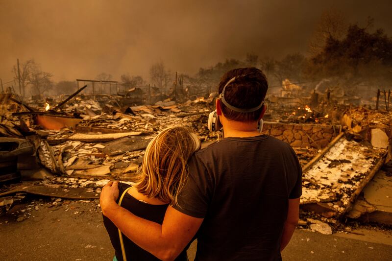 A couple returned to their fire-damaged home after the Eaton blaze swept through the area in Altadena (Ethan Swope/AP)