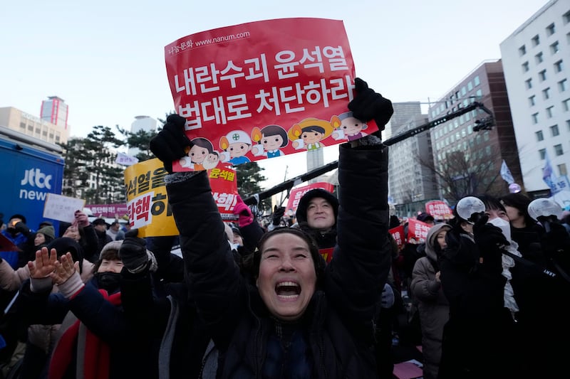 Thousands of people have braved bitter cold outside the National Assembly in Seoul (AP)