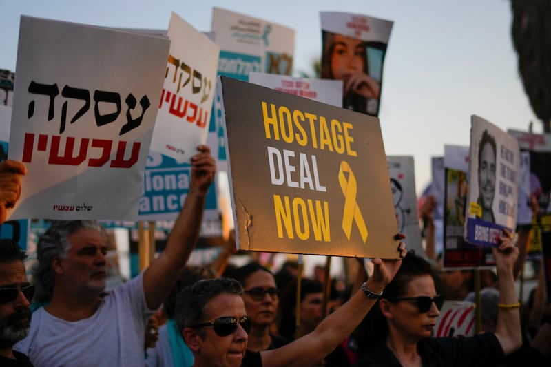 Demonstrators wave signs during a protest calling for the release of the hostages from Hamas captivity in the Gaza Strip (Ariel Schalit/AP)