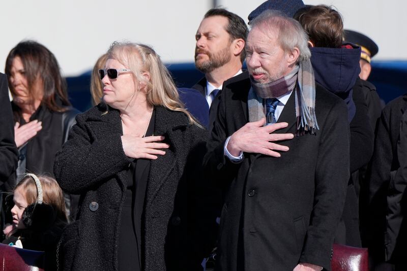 Amy and Jeff Carter watch as the flag-draped casket of their father, former president Jimmy Carter, is placed on Special Air Mission 39 at Dobbins Air Reserve Base in Marietta, Georgia (Alex Brandon/AP)