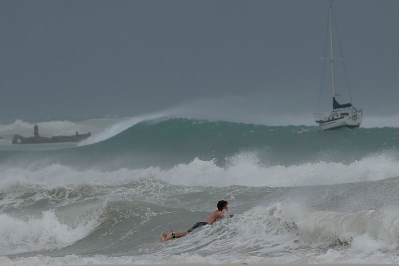 A surfer braves the waves in Carlisle Bay as Hurricane Beryl passes through Bridgetown, Barbados (Ricardo Mazalan/AP)