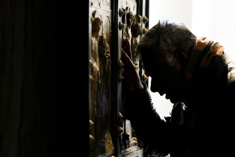 A man stops in prayer as he walks through the Holy Door (AP Photo/Andrew Medichini)