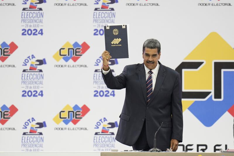 Venezuelan President Nicolas Maduro holds up his certification from the National Electoral Council (CNE) that declares him the winner of the presidential election (Matias Delacroix/AP)