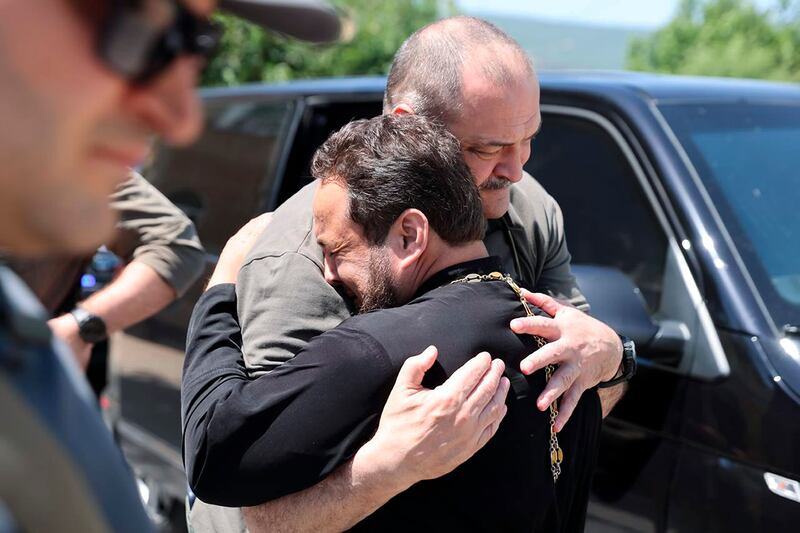 Dagestan governor Sergei Melikov, centre, comforts a priest as he visits the Orthodox Church of the Intercession of the Blessed Virgin Mary in Derbent after the attack (The Telegram Channel of the administration of the head of Dagestan Republic of Russia via AP)