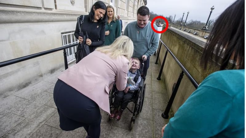 Six-year-old Daithi Mac Gabhann and his parents, father Mairtin Mac Gabhann (right) and mother Seph Ni Mheallain (left) are greeted by Sinn Fein Vice President Michelle O'Neill as they arrive at Parliament Buildings at Stormont in February 2023.  Circled is former Sinn Fein press officer Michael McMonagle. PICTURE: PA