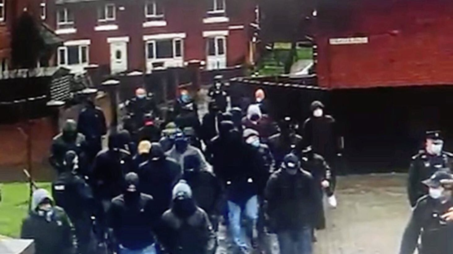 Screen grabs after a video has appeared online of a group of masked men walking round the Pitt Park area of east Belfast 