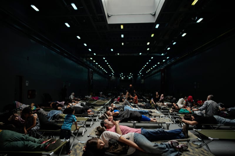 People, mostly Turkish citizens, rest on board of a Turkish military ship evacuating them from Lebanon to Turkey (Emrah Gurel/AP)