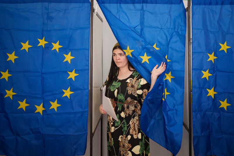 A woman exits a voting cabin after casting her vote in European and local elections in Baleni, Romania (Vadim Ghirda/AP)