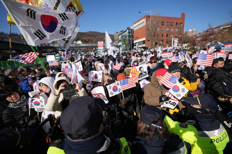 Supporters of impeached South Korean President Yoon Suk Yeol stage a rally after hearing news that a court issued warrants to detain Mr Yoon (Lee Jin-man/AP)