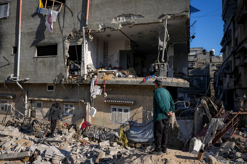 Palestinians look at a damaged residential building after an attack by Israel strike (Abdel Kareem Hana/AP)