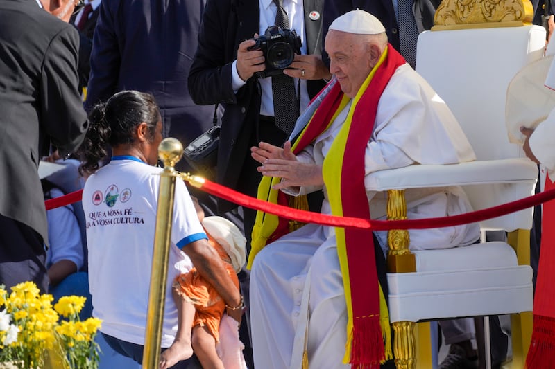 , Pope Francis, wearing an East Timor traditional scarf, blesses a disabled member of the congreation (Gregorio Borgia/AP)