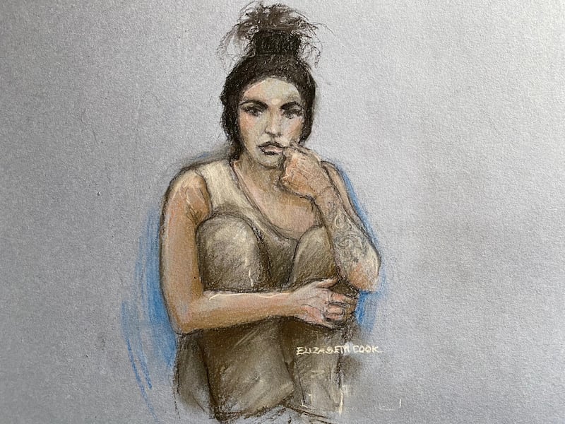 Court artist sketch of Katie Price sitting with her knees up while appearing by video link before a specialist bankruptcy judge