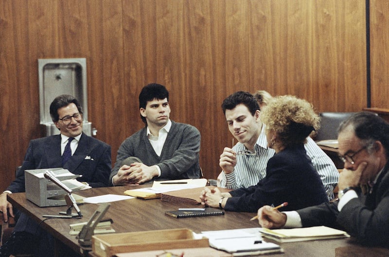 Erik Menendez, centre, listens to his lawyer as his brother Lyle looks on in court in 1991 (Julie Markes/AP)