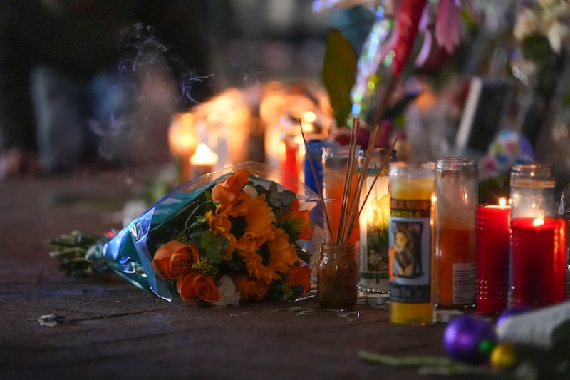 Flowers lie next to candles at a memorial for the victims of the attack (Gerald Herbert/AP)