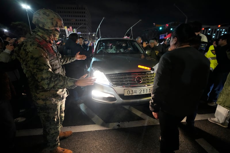 People block a martial law vehicle as they gather in front of the National Assembly in Seoul to demand South Korean President Yoon Suk Yeol step down (Ahn Young-joon/AP)