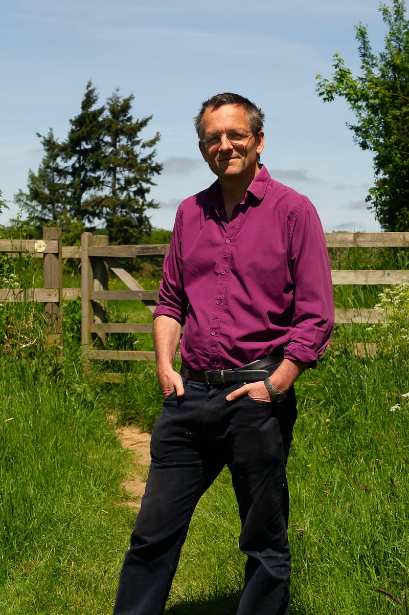 Dr Michael Mosley standing in a field wearing a purple shirt