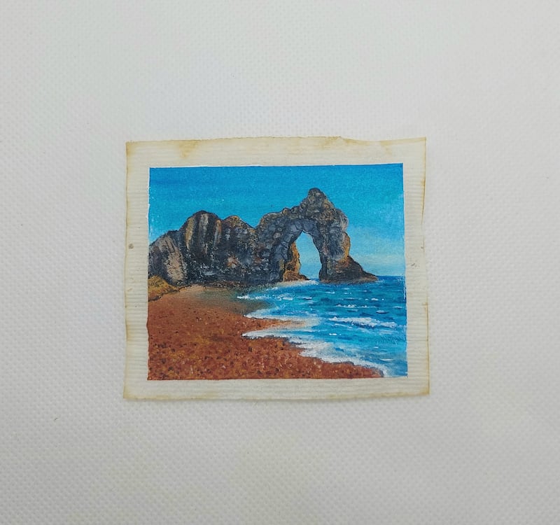 Caroline West’s painting of Durdle Door on a used tea bag