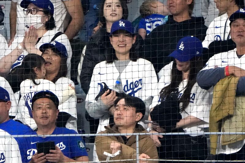 Mamiko Tanaka, centre, wife of Los Angeles Dodgers’ Shohei Ohtani, watches during an opening day baseball game between the San Diego Padres and the Dodgers at the Gocheok Sky Dome in Seoul, South Korea (Ahn Young-joon/AP)