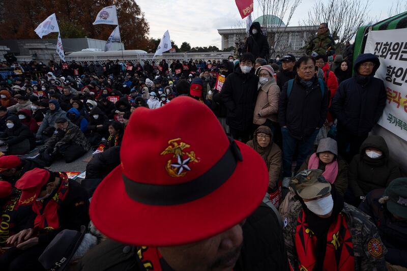 People gather outside the National Assembly during the voting for the impeachment of South Korean President Yoon Suk Yeol (Ng Han Guan/AP)