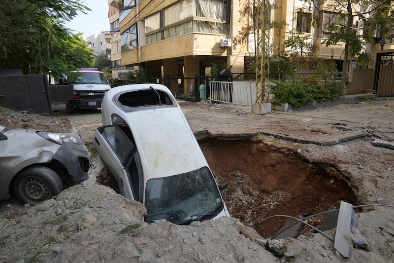 A car sits in a crater in Beirut’s southern suburbs on Saturday