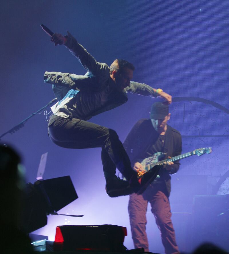 Chris Martin of Coldplay jumps as he performs at the Glastonbury Music Festival in 2011