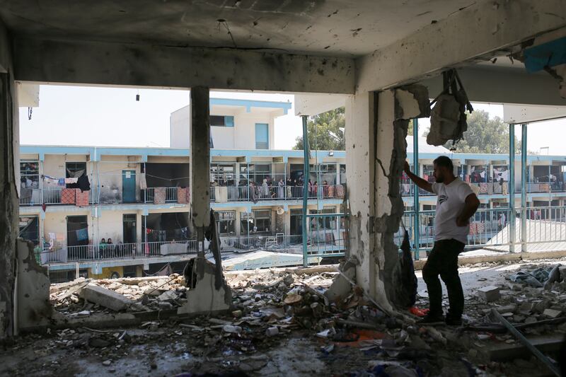 Palestinians look at the aftermath of the Israeli strike on a UN-run school that killed dozens of people in the Nusseirat refugee camp in the Gaza Strip (Jehad Alshrafi/AP)
