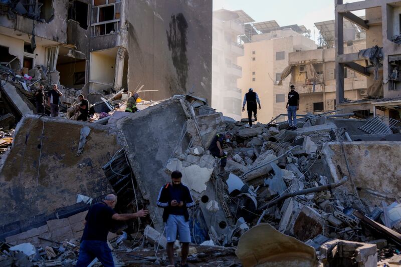 Residents check the site of an Israeli air strike in Tayouneh, Beirut, Lebanon (Hassan Ammar/AP)