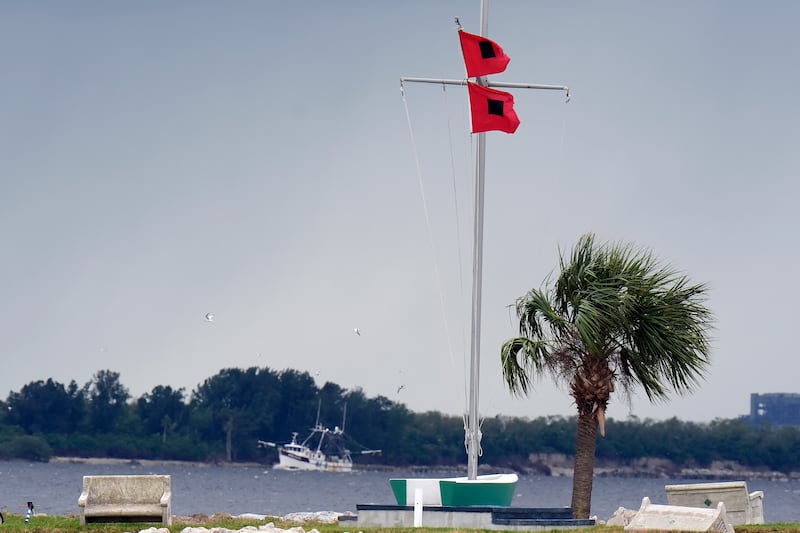 A shrimping boat makes her way back to port as hurricane flags fly at the Davis Islands Yacht Club in Tampa, Florida (Chris O’Meara/AP)