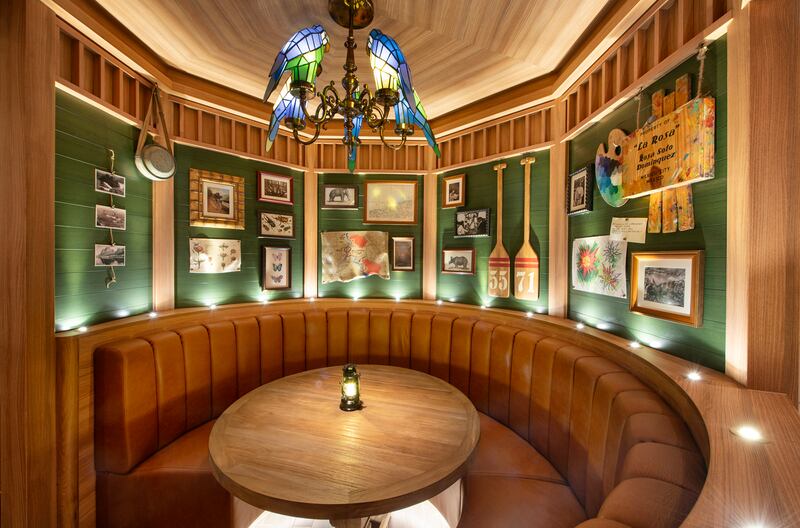 A circular wooden booth filled with memorabilia in Skipper Society on board the Disney Treasure