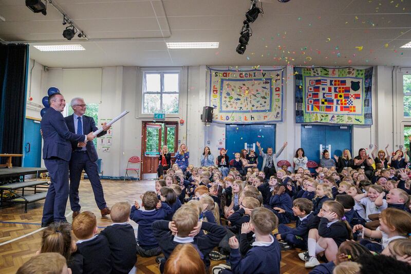 Paul Givan (left) and Principal Peter Campbell let off a confetti canon at Bangor Central Integrated Primary school. PICTURE: LIAM MCBURNEY/PA