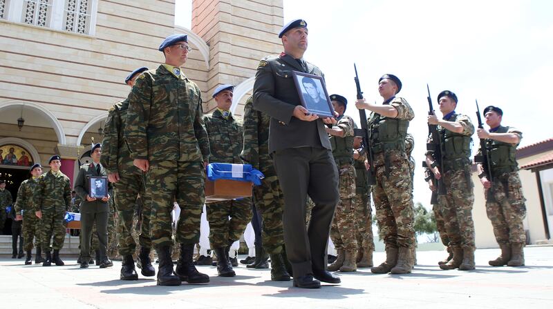 Soldiers carrying the coffins of Greek soldiers whose remains were recently identified, process past Ayios Panteleimonas Orthodox Church in Nicosia (Philippos Christou/AP)
