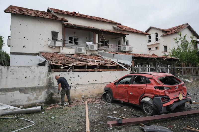 An Israeli police bomb squad officer inspects the site after a missile fired from Lebanon hit the area in Petah Tikva, Israel (Oded Balilty/AP)