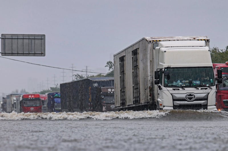 Vehicles drive through floodwater in Shenyang in north-eastern China’s Liaoning province (Wang Hongtao/Xinhua News Agency/AP)