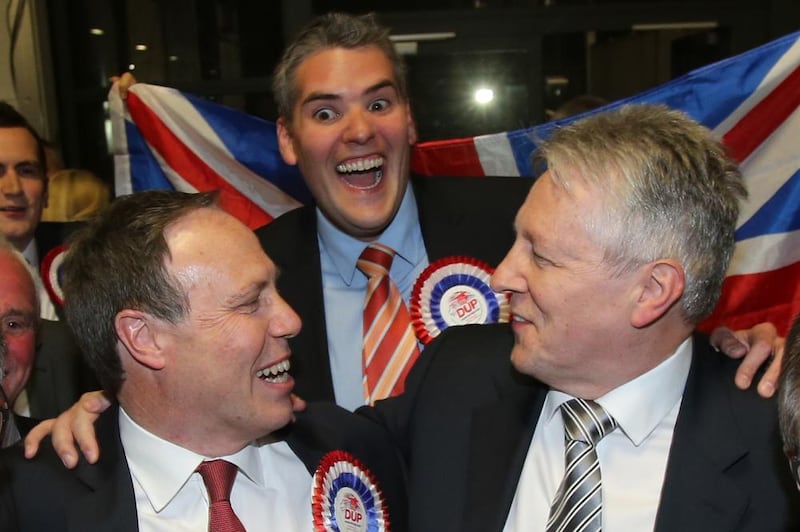 DUP leader Peter Robinson celebrates with unionist unity candidates Nigel Dodds and Gavin Robinson at the King&#39;s Hall in Belfast. Picture by Niall Carson/PA Wire 