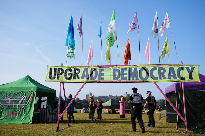 Police walk beneath a banner reading ‘upgrade democracy’