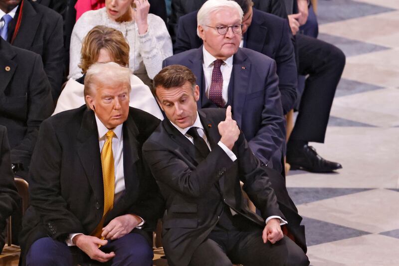 Emmanuel Macron points towards Germany’s President Frank-Walter Steinmeier, right rear, as he talks with Donald Trump in Notre Dame Cathedral (Ludovic Marin, Pool via AP)