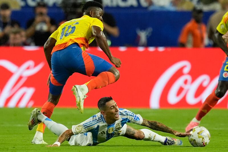 Argentina’s Angel Di Maria falls while fighting for the ball with Colombia’s Jefferson Lerma (Rebecca Blackwell/AP)