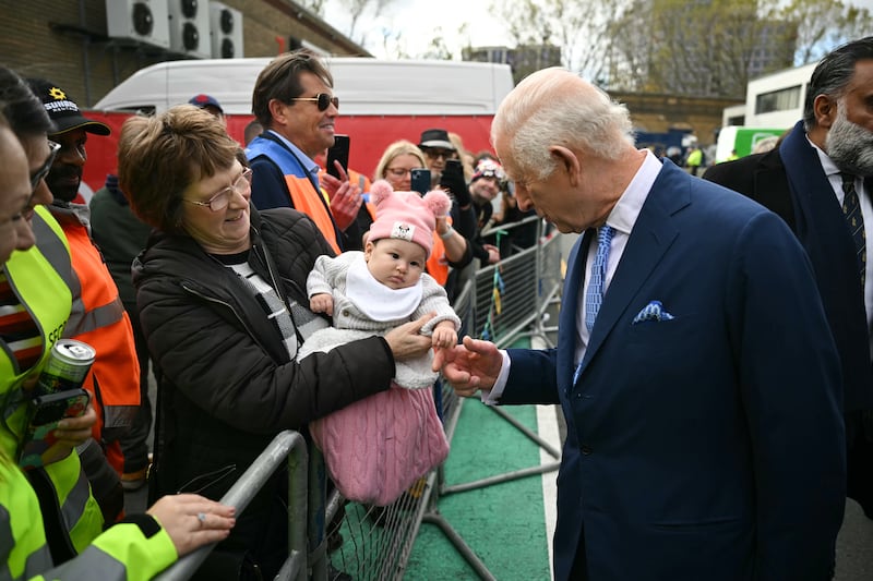 Charles greets a baby during a visit to Deptford, south-east London, on his 76th birthday