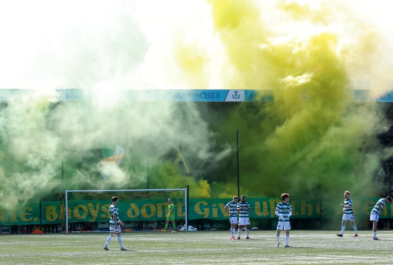 Smoke from flares billow above an ‘unapproved’ banner in the Celtic end