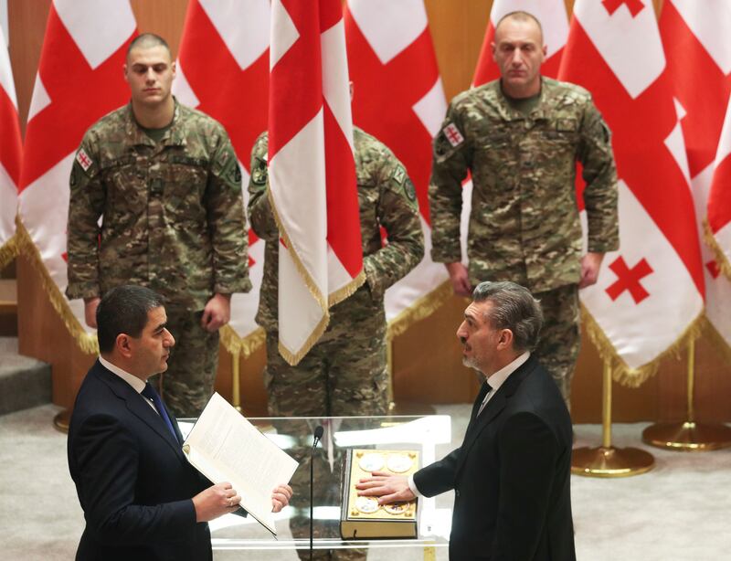 President-elect Mikheil Kavelashvili, right, takes the oath during his swearing-in ceremony at the Georgian parliament in Tbilisi (Irakli Gedenidze/Pool/AP)