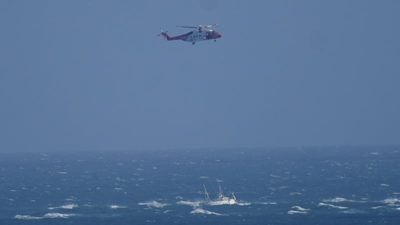 A helicopter from the Irish Coast Guard hovers above a stranded boat off the coast of Blackwater, Wexford (Niall Carson/PA)